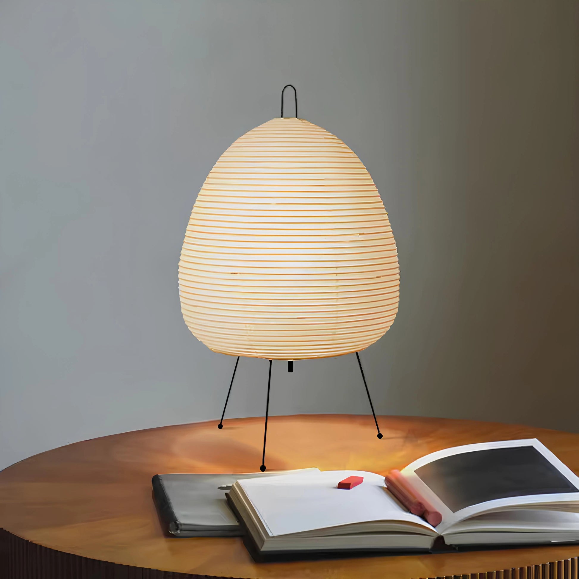 Lummero - table lamp with a woven design on a wooden table next to an open book.